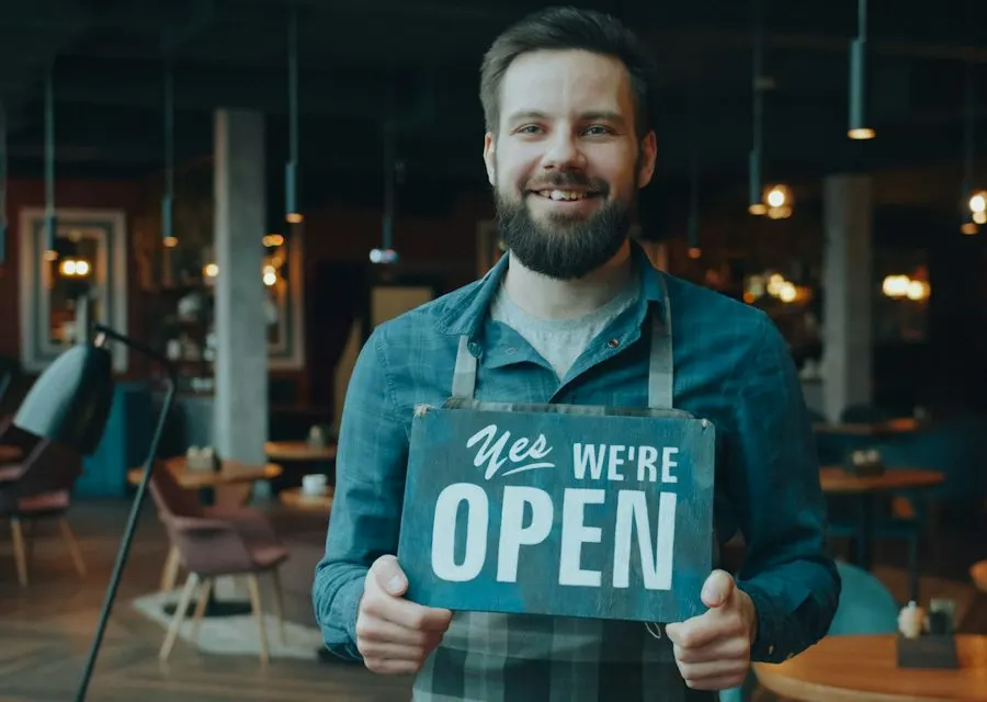 Business owner holding a We’re Open sign